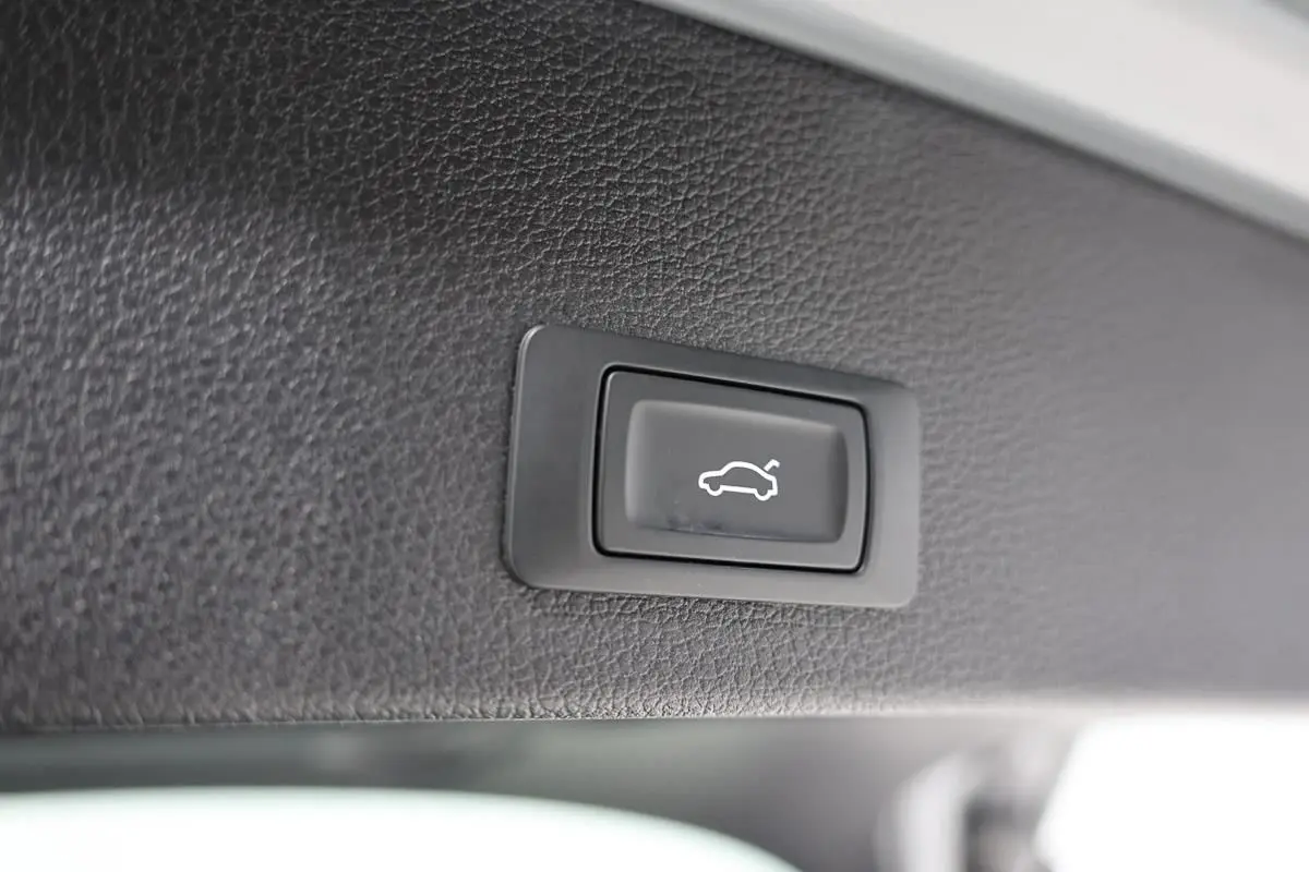 Bouton noir d'ouverture électrique du hayon sur garniture intérieure en cuir gris foncé de l'Audi Q2 2023.