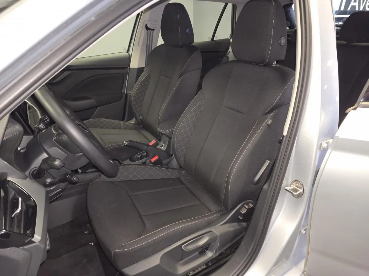 Vue intérieure côté conducteur du Skoda Kamiq gris 2023, sièges tissu noir avec surpiqûres contrastées.