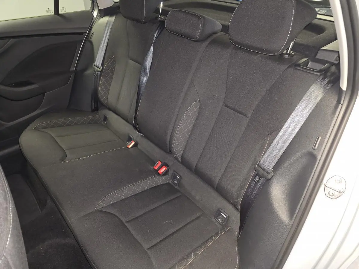 Vue intérieure de la banquette arrière noire du Skoda Kamiq 2023, avec ceintures de sécurité et appuie-têtes visibles.