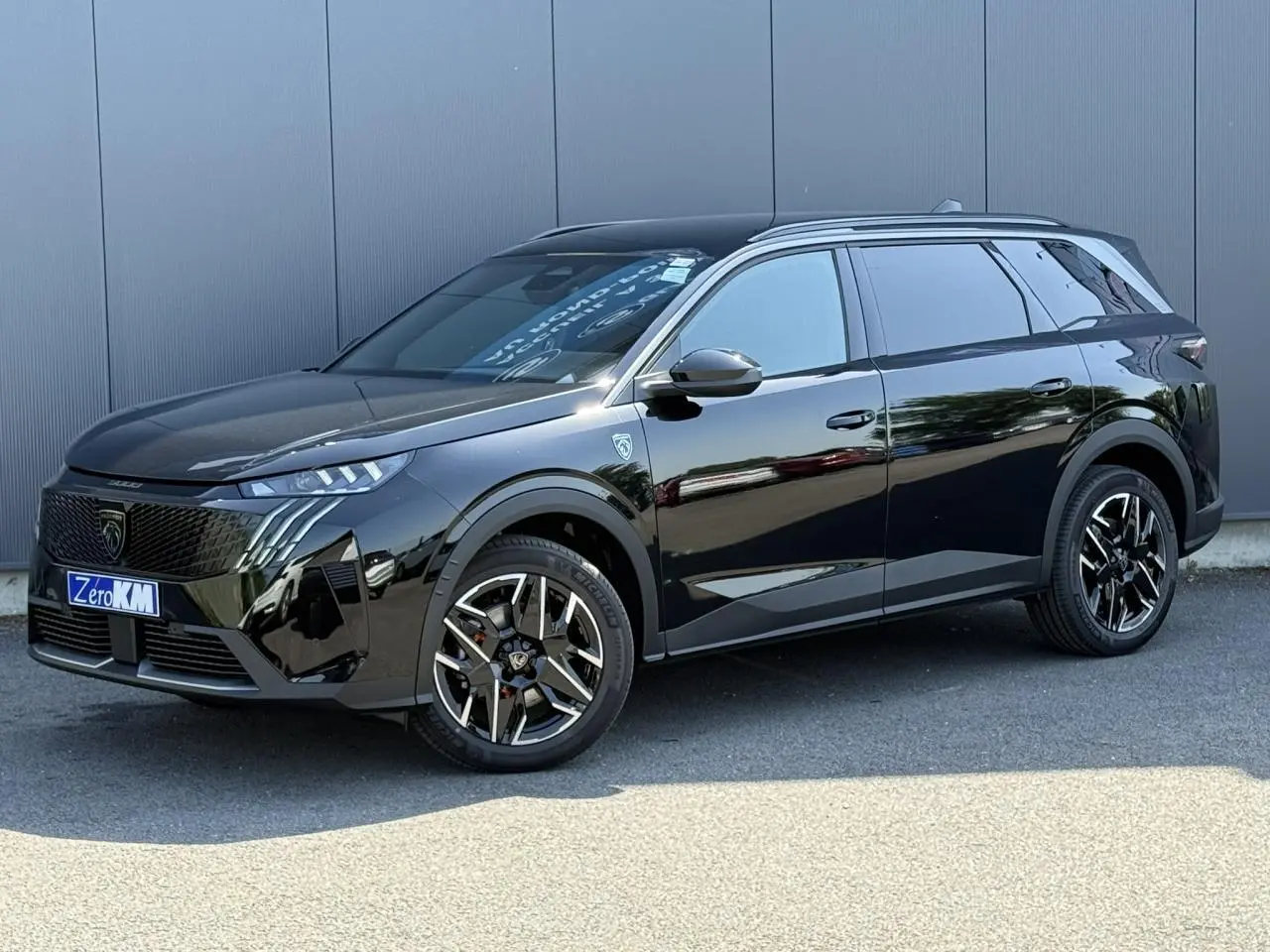 Peugeot 5008 Hybrid 145 GT noir Perla en vue 3/4 avant droit avec jantes alliage noires et hayon électrique.