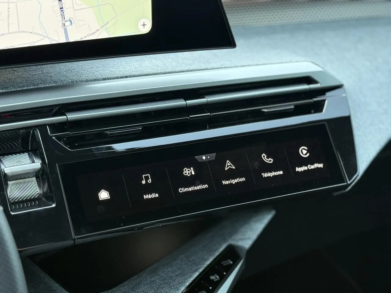 Vue rapprochée de la console centrale du Peugeot 5008 Hybrid 2026, écran tactile avec menu multimédia et finition Alcantara gris.