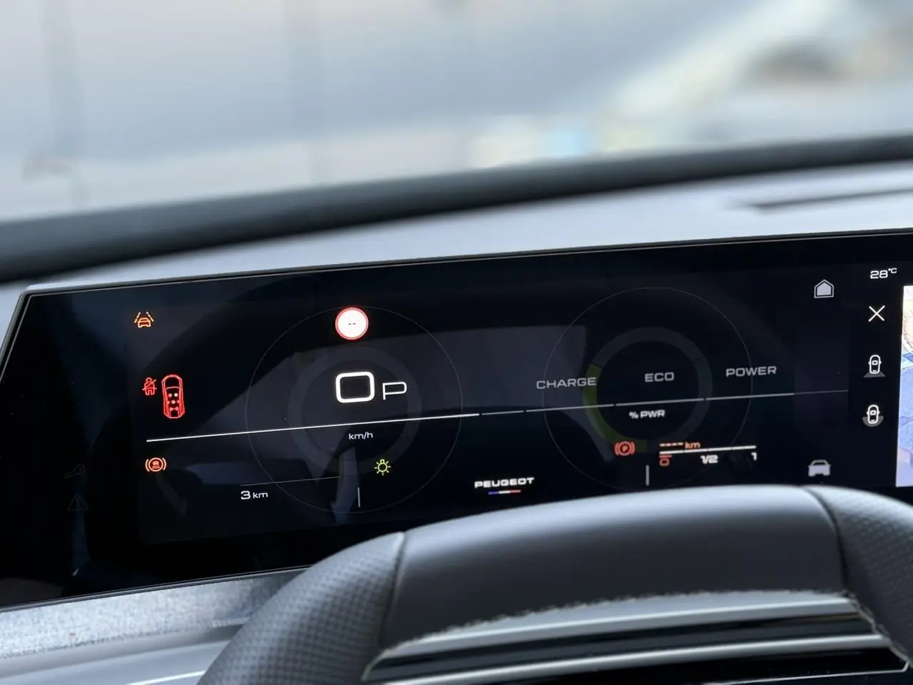Tableau de bord numérique du Peugeot 5008 Hybrid 2026 vu de face, affichage mode ECO et vitesse à zéro.