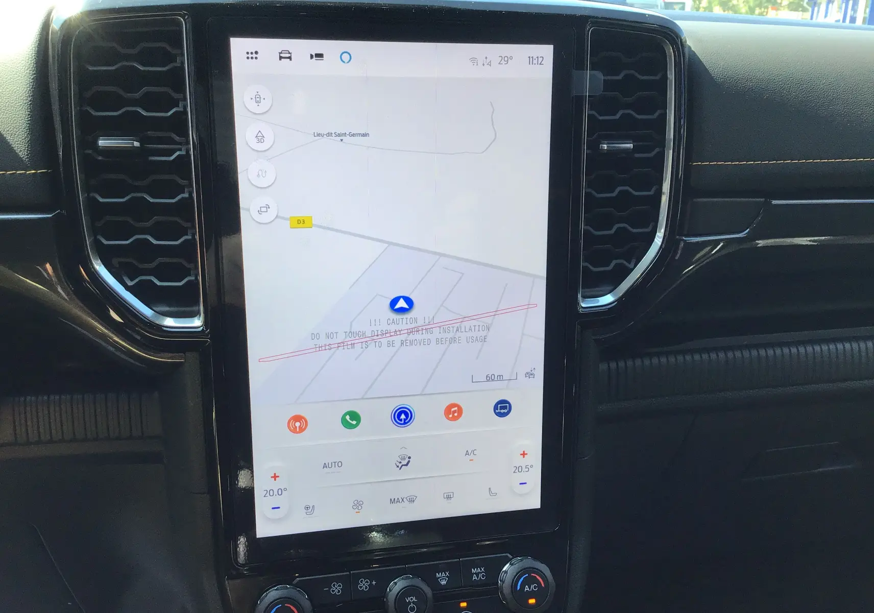 Écran tactile central du Ford Ranger Wildtrak 2025 montrant la navigation et les commandes climatisation, intérieur noir avec surpiqûres jaunes.