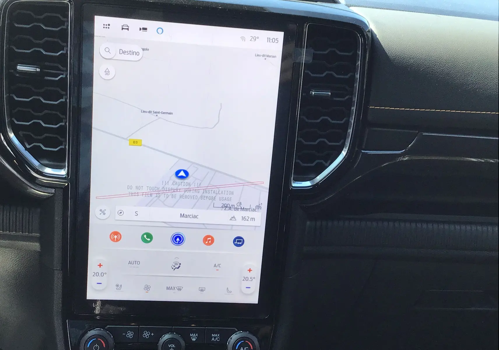 Écran tactile central du Ford Ranger Wildtrak 2025 avec navigation et commandes climatisation visibles sur tableau de bord noir.