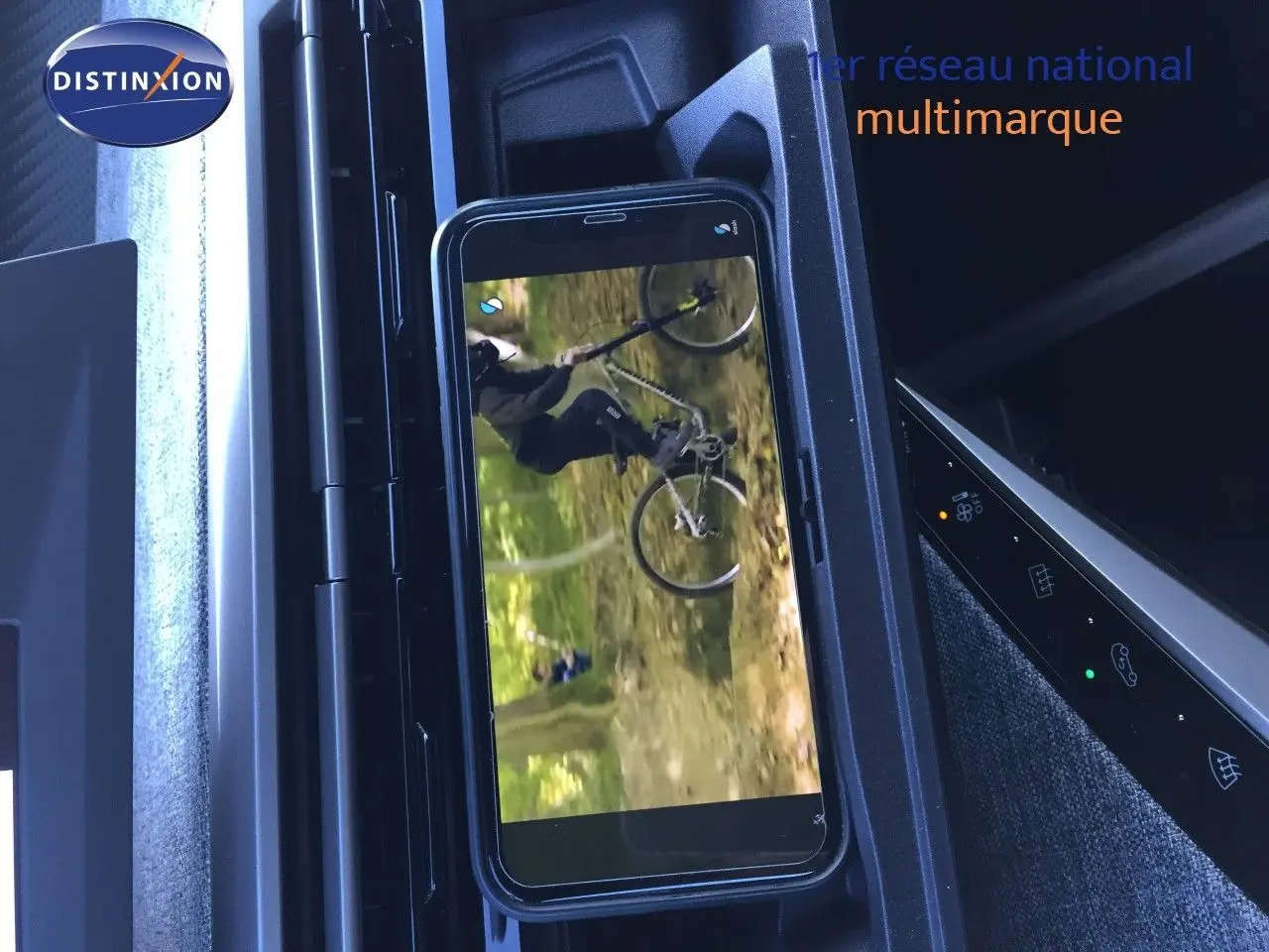 Intérieur du Peugeot 5008 Hybrid 2025 montrant le support smartphone et la console centrale noire avec commandes tactiles.