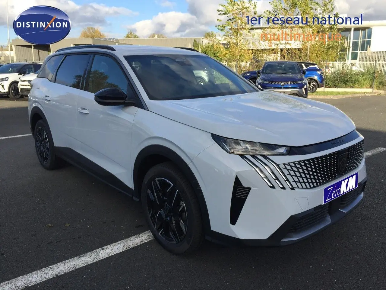 Peugeot 5008 Hybrid blanc Okenite métal en vue 3/4 avant droit, avec calandre distinctive et jantes noires.