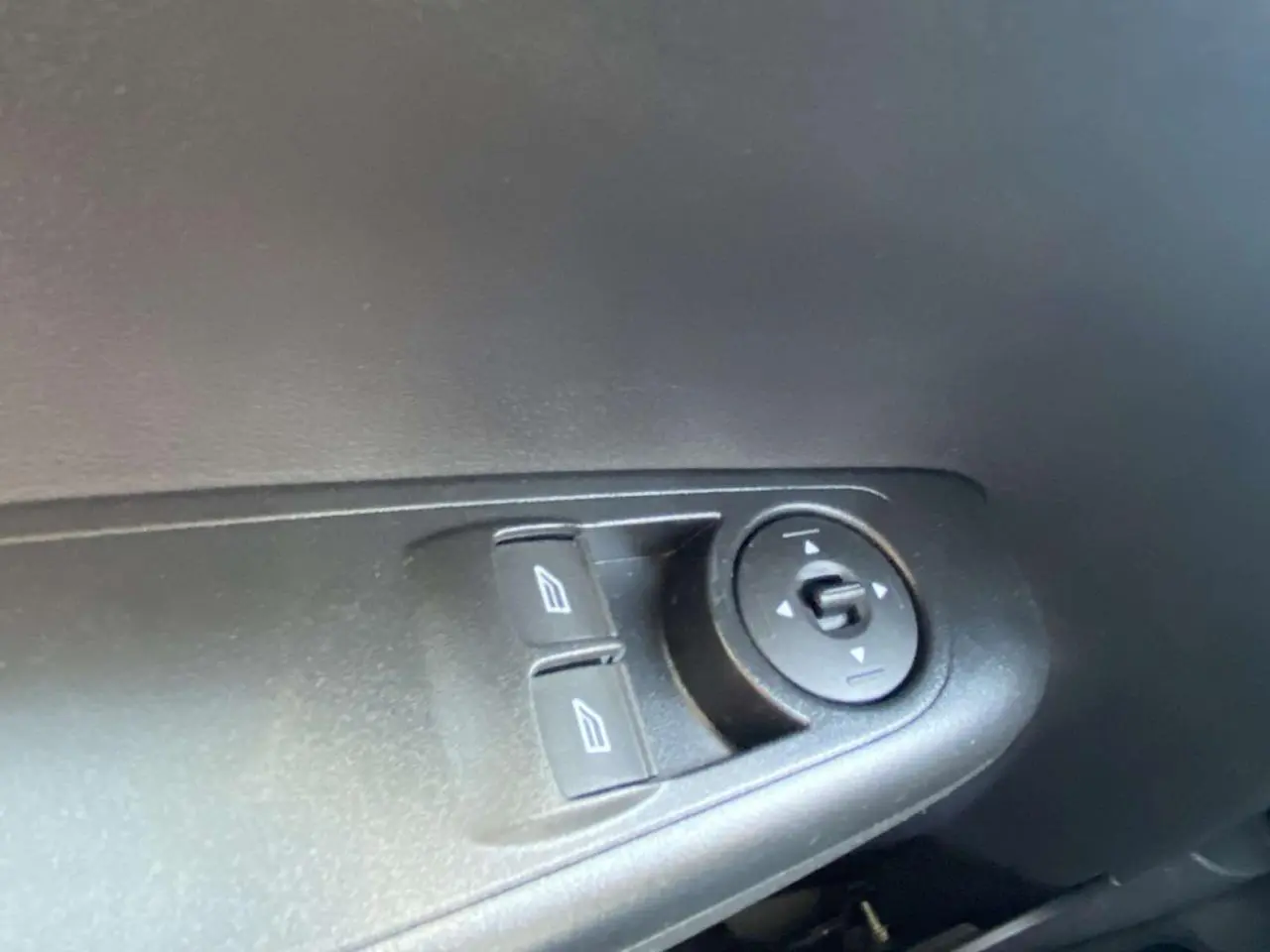 Gros plan sur les commandes électriques des vitres et rétroviseurs côté gauche intérieur du Ford Tourneo Courier blanc 2022.