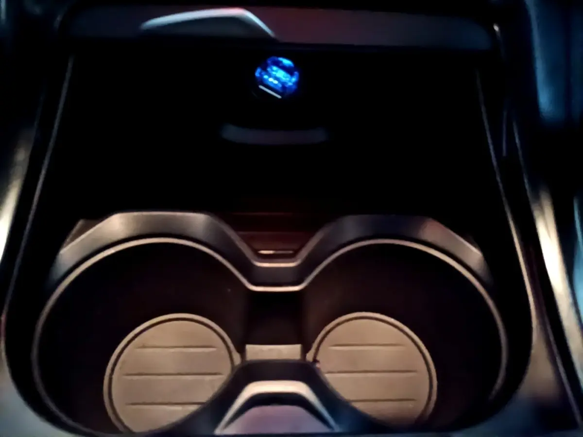 Gros plan sur les porte-gobelets noirs au centre de la console intérieure du BMW X2 sDrive18i Lounge DKG7 2023.