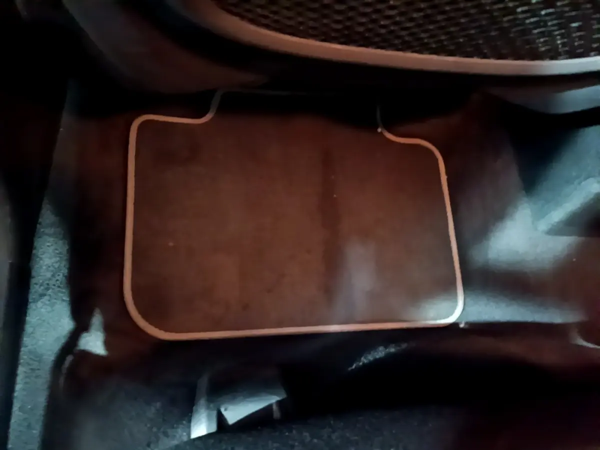 Vue rapprochée du tapis de sol noir à bord beige à l'avant d'un BMW X2 sDrive18i Lounge 2023.