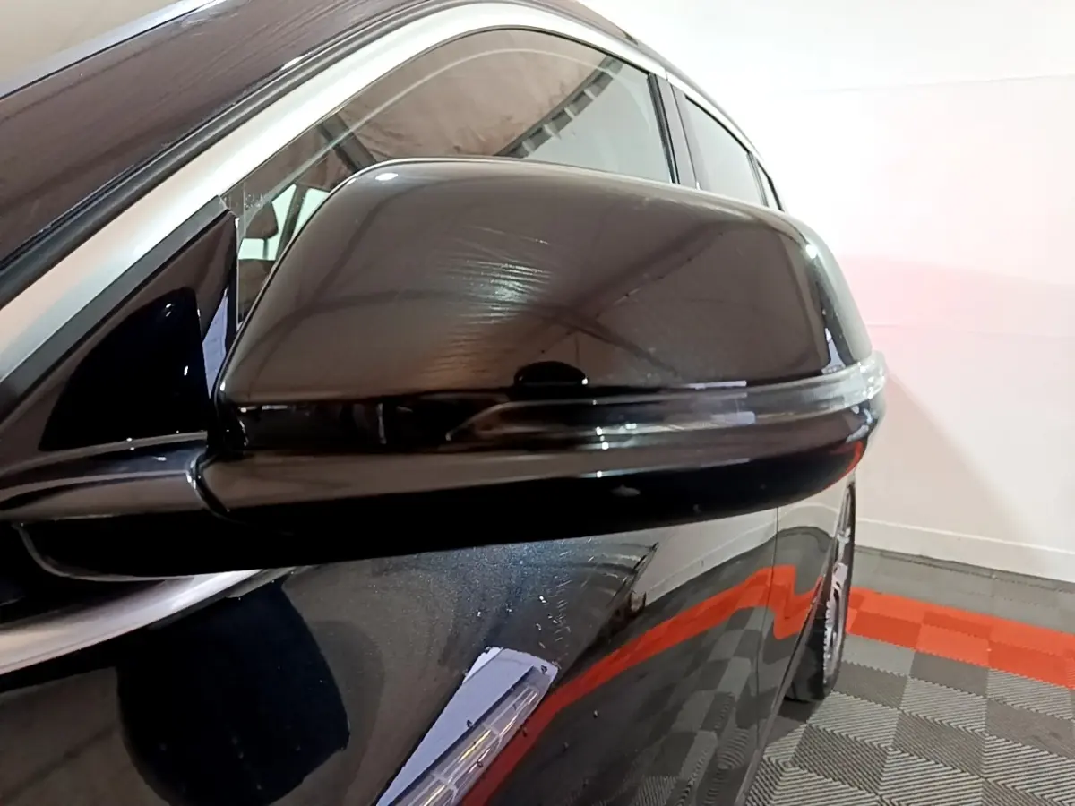 Gros plan sur le rétroviseur droit noir brillant du BMW X2 sDrive18i Lounge 2023 avec clignotant intégré.