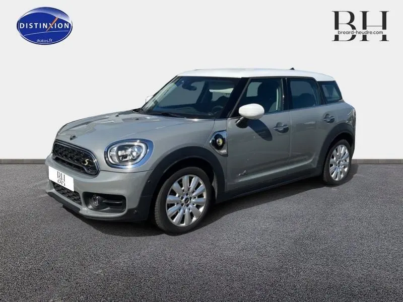 Vue 3/4 avant droit d'une MINI Countryman Cooper SE Moonwalk Grey avec toit blanc et jantes alu design Pin Spoke.