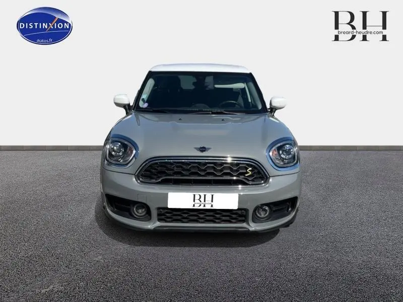 Vue frontale d'une MINI COUNTRYMAN Cooper SE Moonwalk Grey avec toit blanc et calandre chromée distinctive.