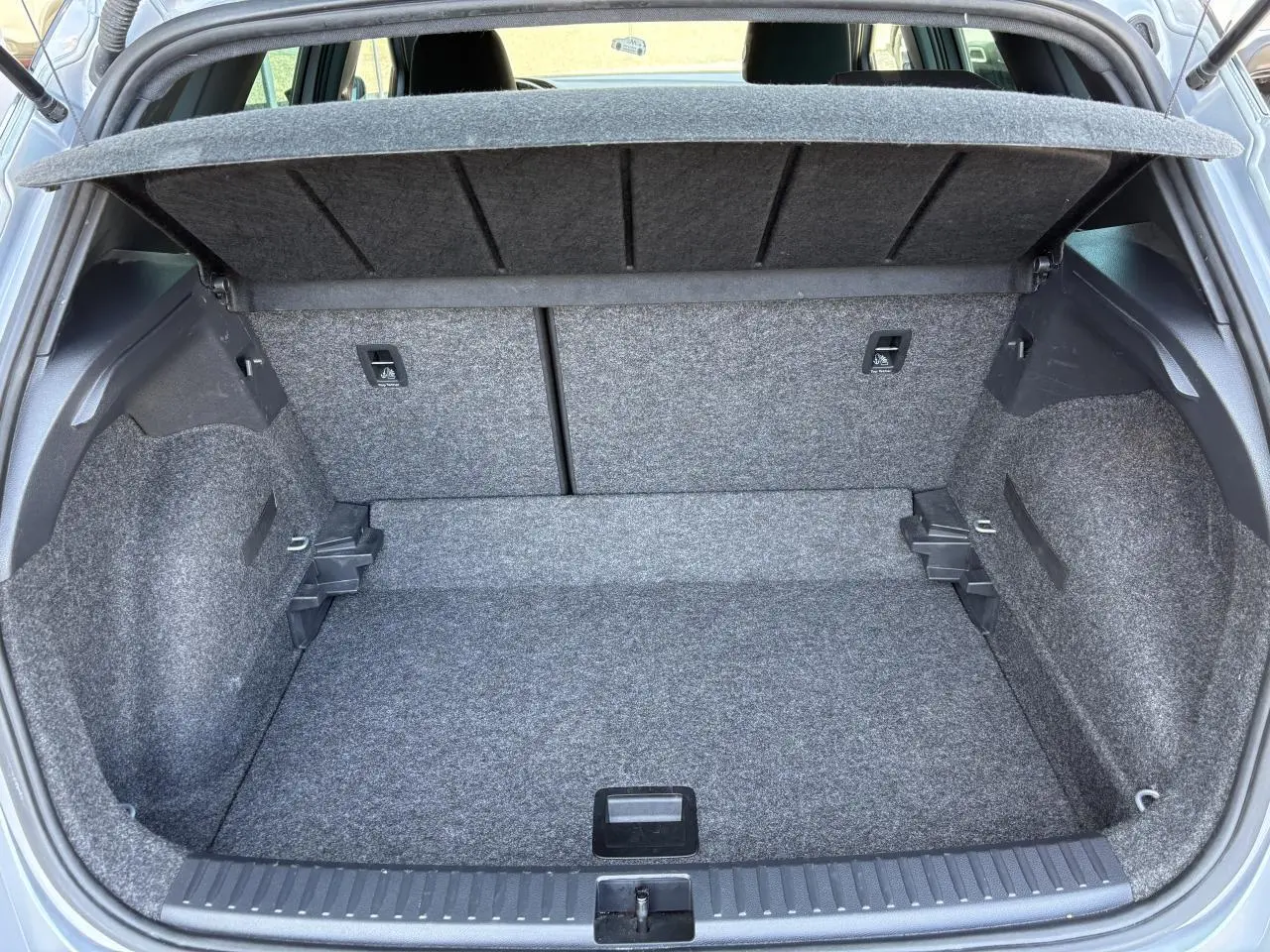 Coffre ouvert vu de l'arrière d'une SEAT Arona 2024, finition FR, avec intérieur gris et plancher plat.