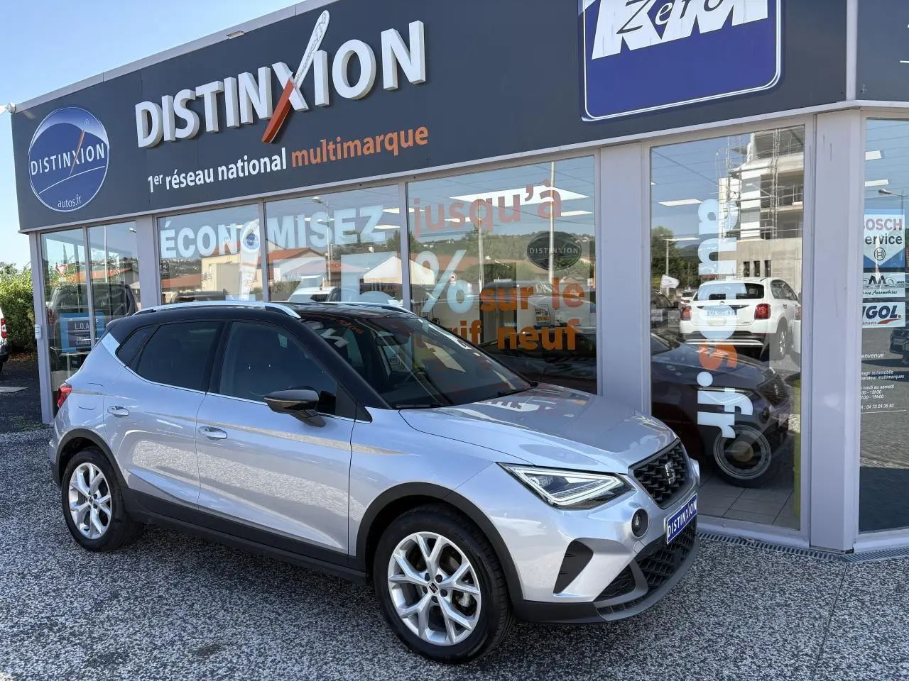 SEAT Arona 2024 gris GRS en 3/4 avant droit, avec jantes alliage 16 pouces et calandre noire distinctive.