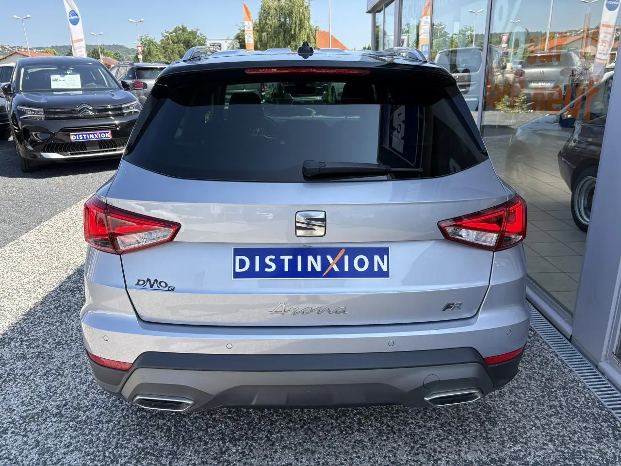 Vue arrière d'un SEAT Arona 2024 gris clair avec logo FR et double sortie d'échappement intégrée au pare-chocs.