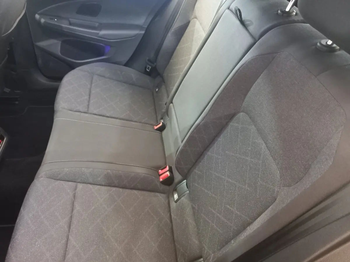 Vue intérieure du siège arrière gris foncé de la Volkswagen Golf 1.5 ETSI 2022 avec ceinture et appuie-tête visibles.
