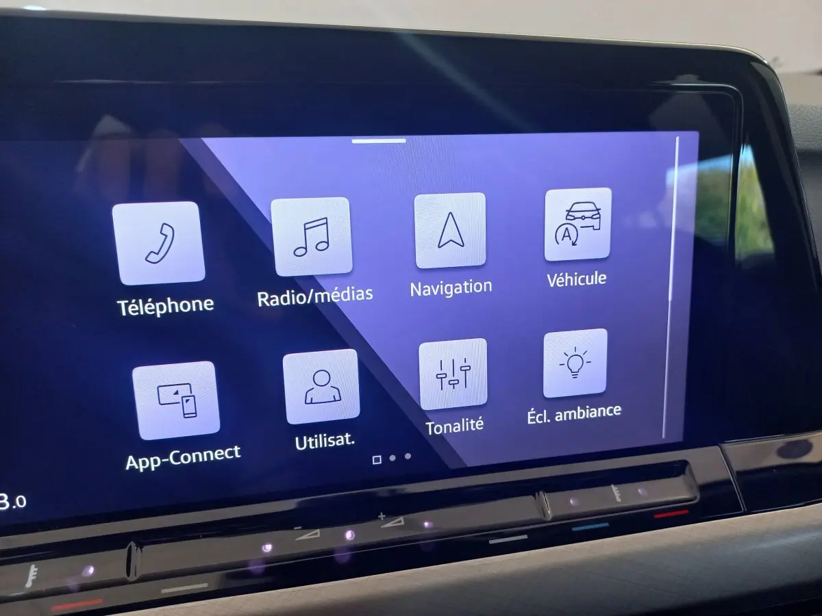 Écran tactile central de la Volkswagen Golf 1.5 bleu, affichant les menus téléphone, navigation et ambiance lumineuse.