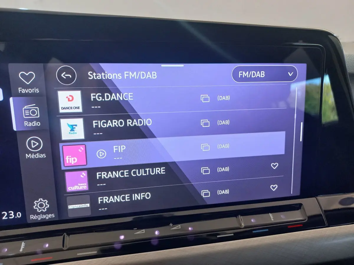 Écran tactile central de la Volkswagen Golf 1.5 bleu, affichant les stations radio FM/DAB avec interface moderne.