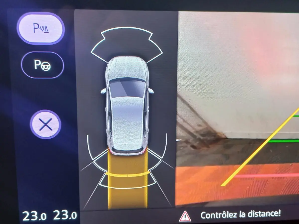Affichage écran tactile montrant la vue aérienne du véhicule en gris avec assistance au stationnement active.