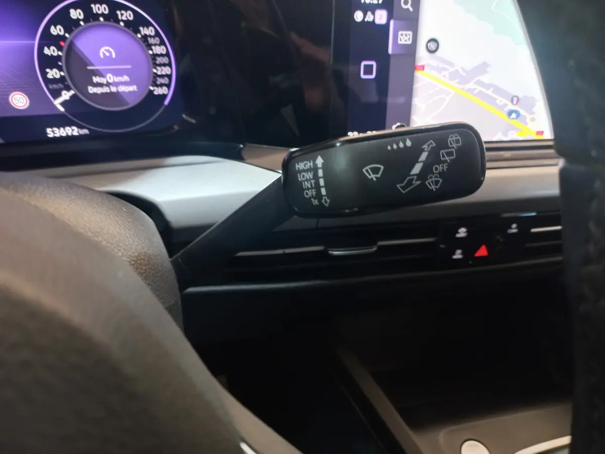 Gros plan sur la commande d’essuie-glace à gauche du volant dans l’habitacle d’une Volkswagen Golf bleue 2022.