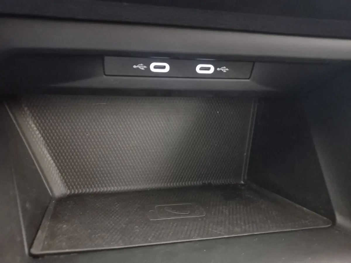 Zone de recharge par induction avec deux ports USB-C éclairés dans une Volkswagen Golf 2022 bleu.