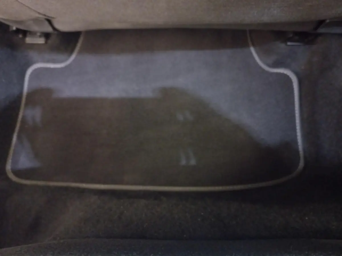 Tapis de sol noir avec surpiqûres claires dans l'habitacle avant d'une Volkswagen Golf bleue 2022.