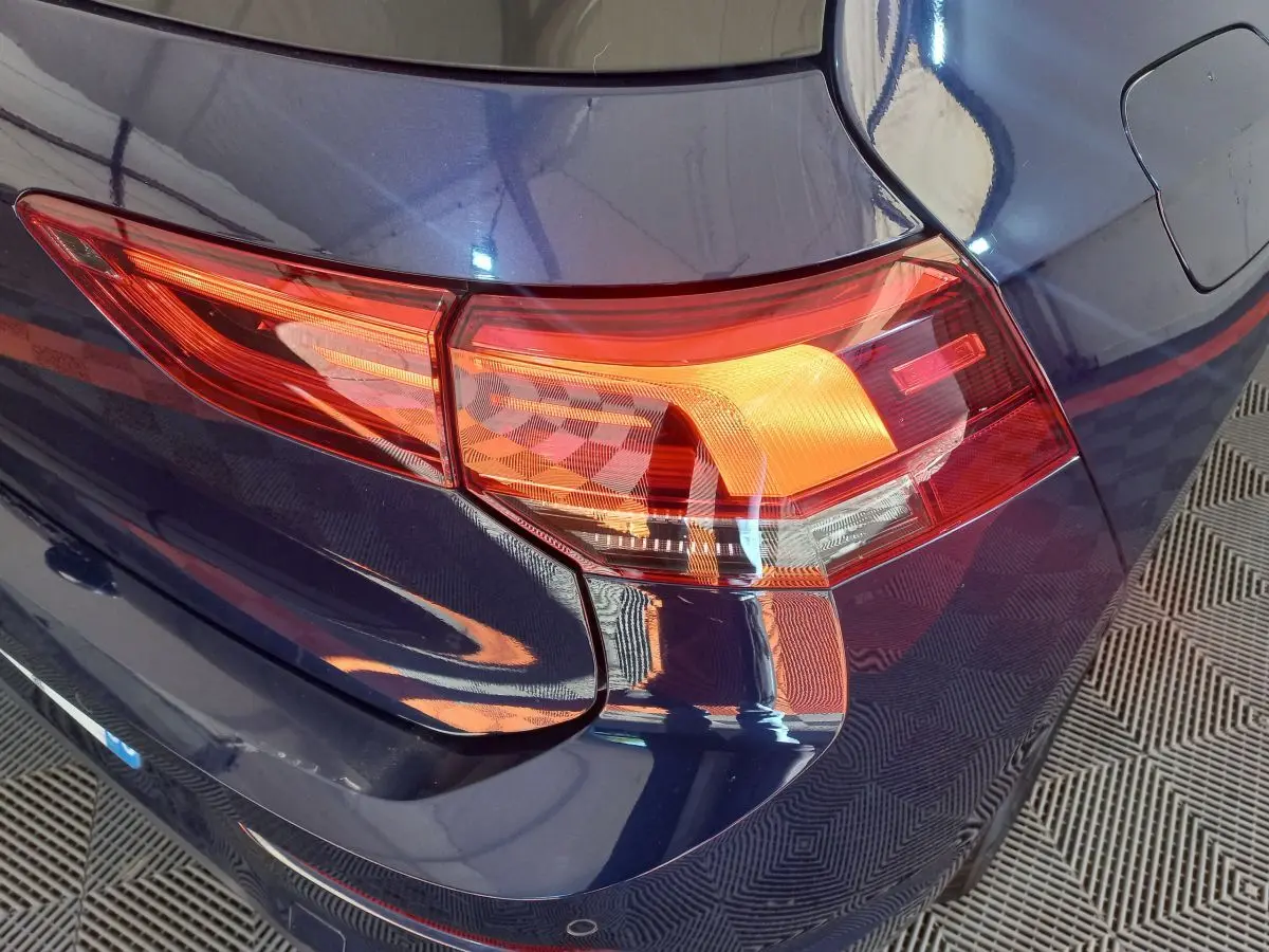 Gros plan sur le feu arrière droit d'une Volkswagen Golf 2022 bleu profond, soulignant ses lignes modernes.