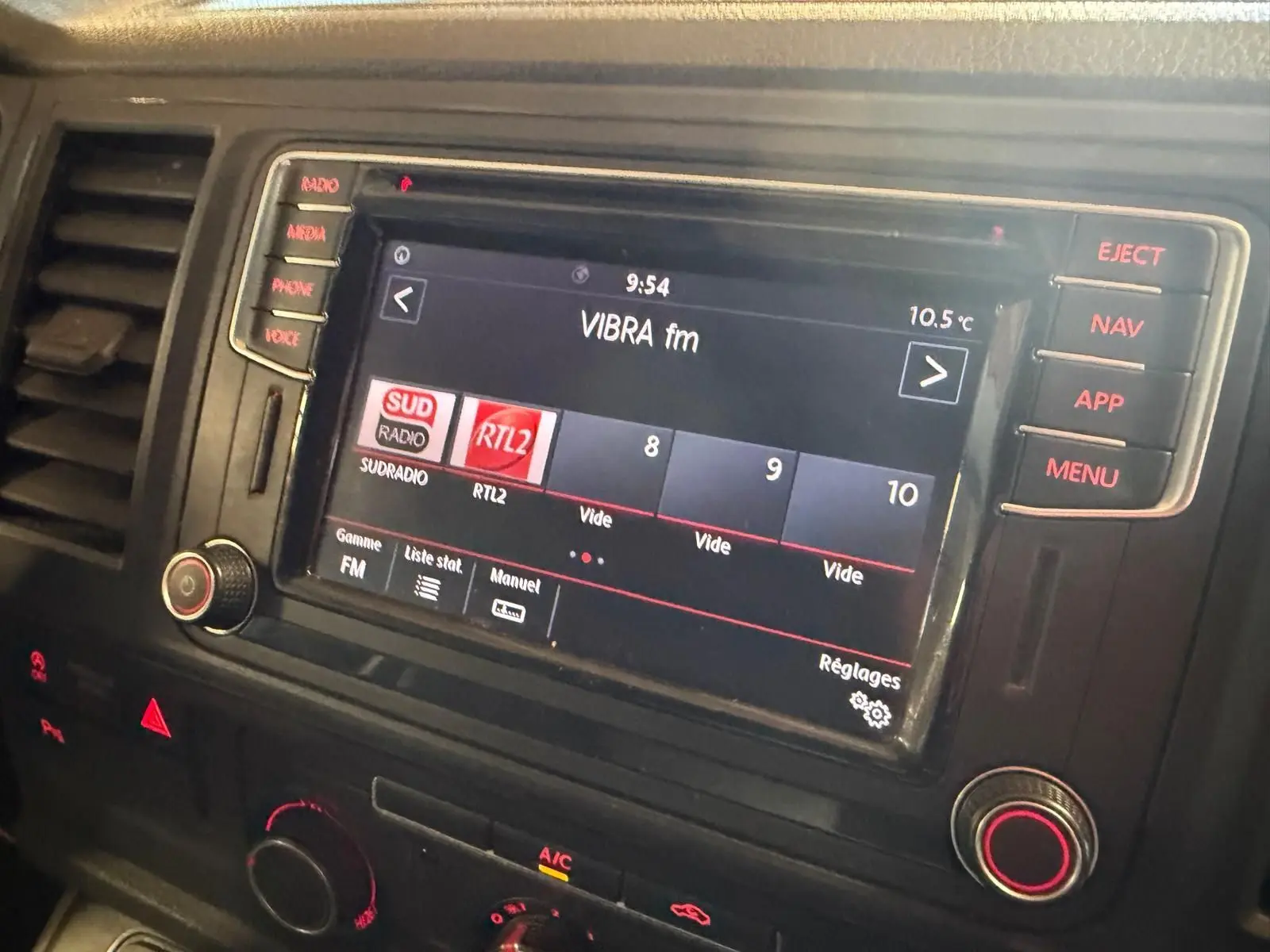 Vue rapprochée de l’écran multimédia du Volkswagen Transporter 2019 avec affichage de stations radio et commandes tactiles.