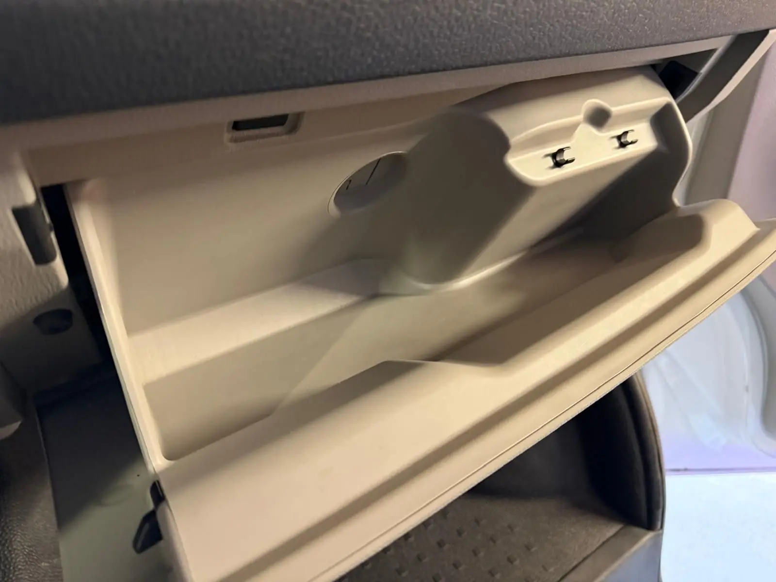 Vue rapprochée de la boîte à gants beige ouverte dans l'habitacle du Volkswagen Transporter blanc 2019.