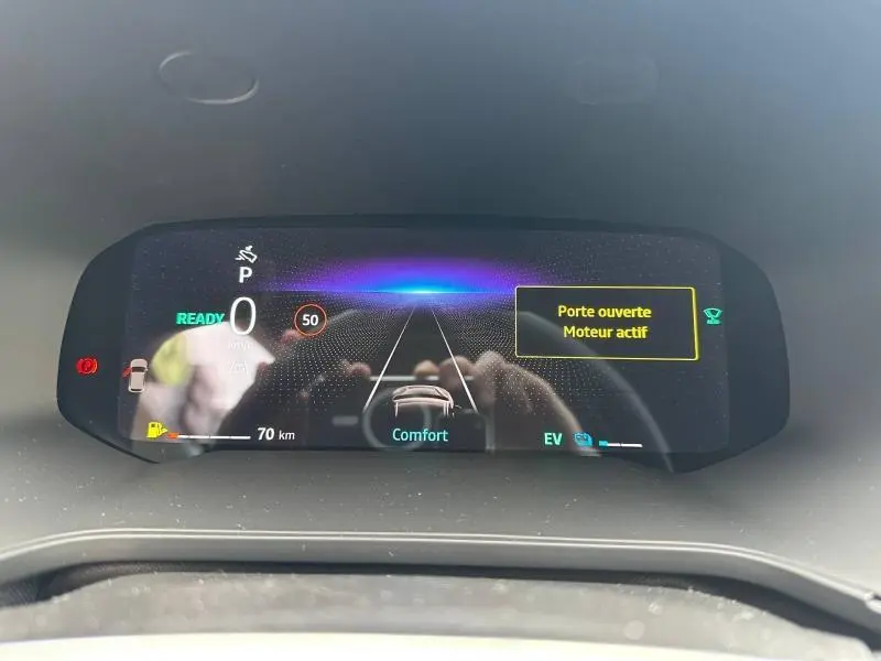 Tableau de bord numérique du Renault Captur 2026 affichant la vitesse, mode confort et avertissement porte ouverte.