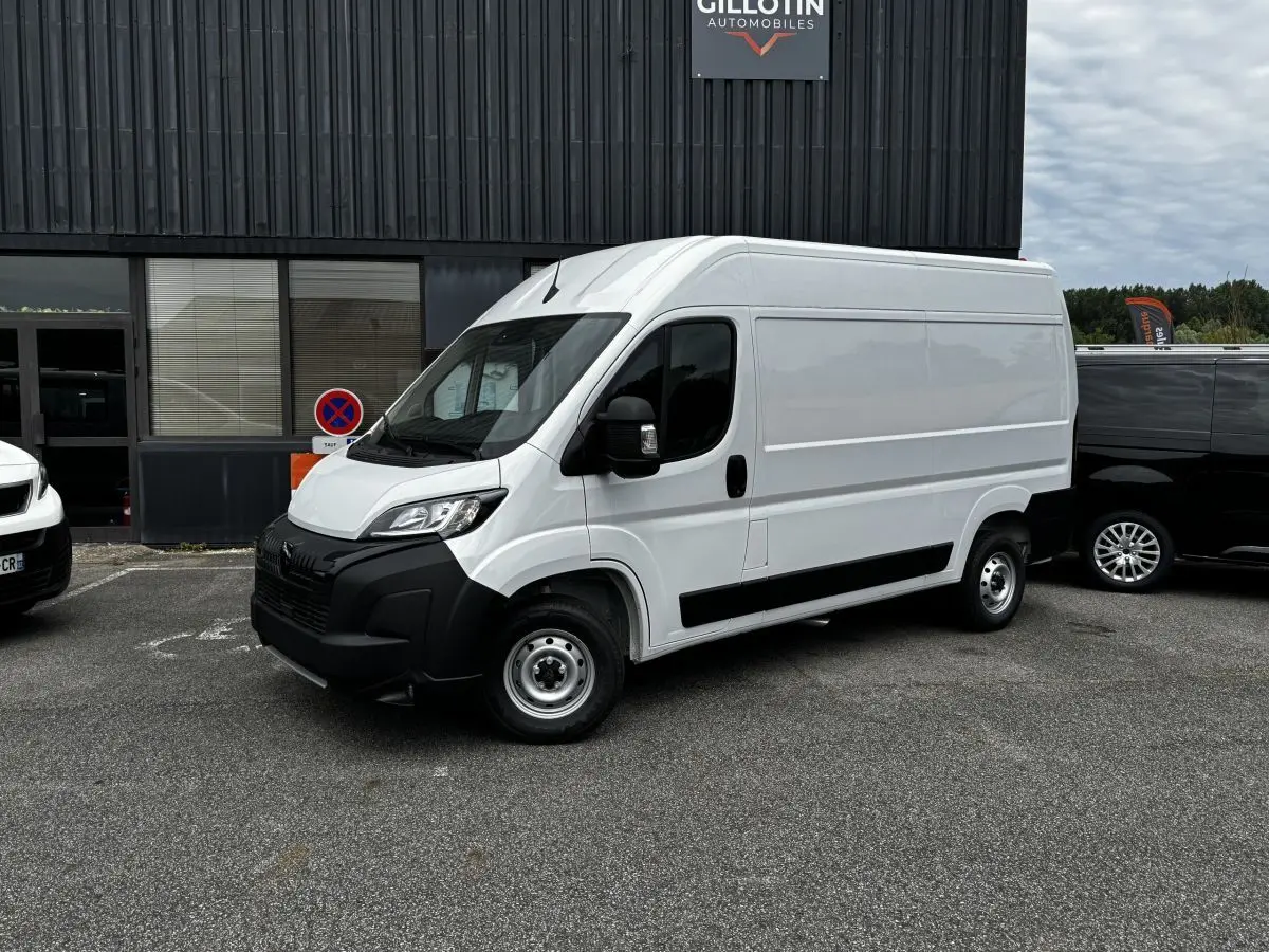 Peugeot Boxer Fourgon blanc en vue 3/4 avant droit, avec pare-chocs noirs et jantes acier simples.