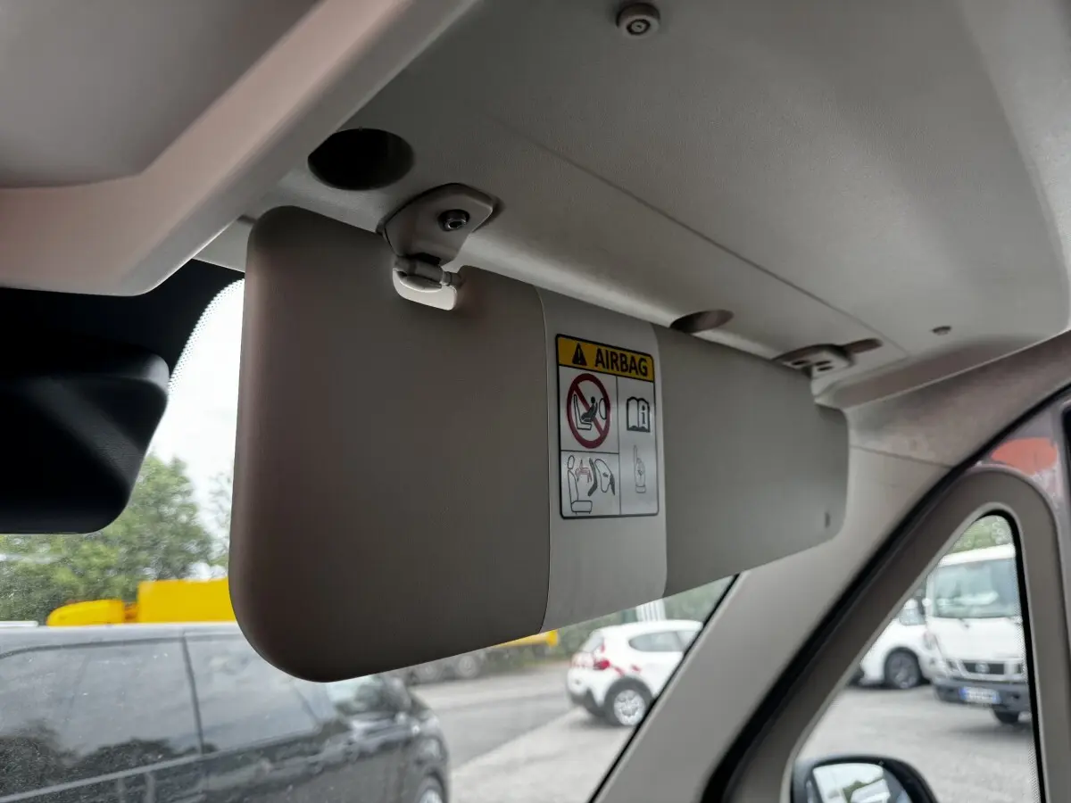 Vue intérieure sur le pare-soleil gris clair côté conducteur du Peugeot Boxer Fourgon blanc, avec avertissement airbag visible.