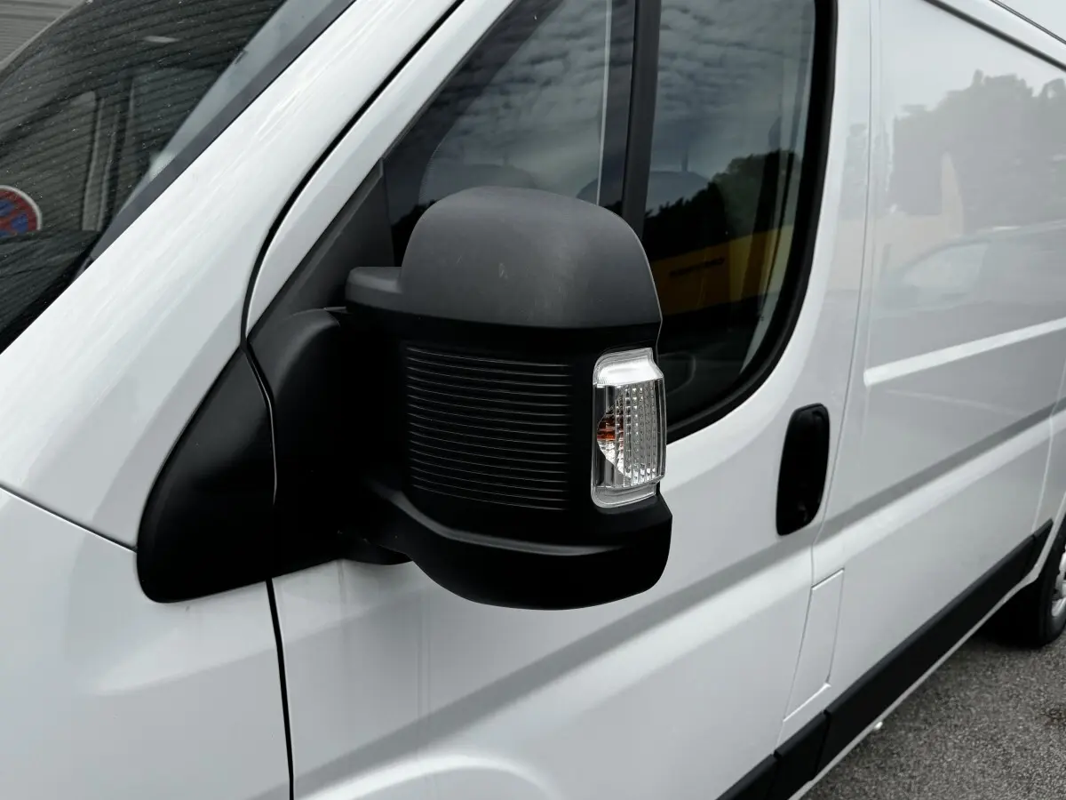 Gros plan sur le rétroviseur droit noir du Peugeot Boxer Fourgon blanc, côté conducteur, avec porte coulissante visible.