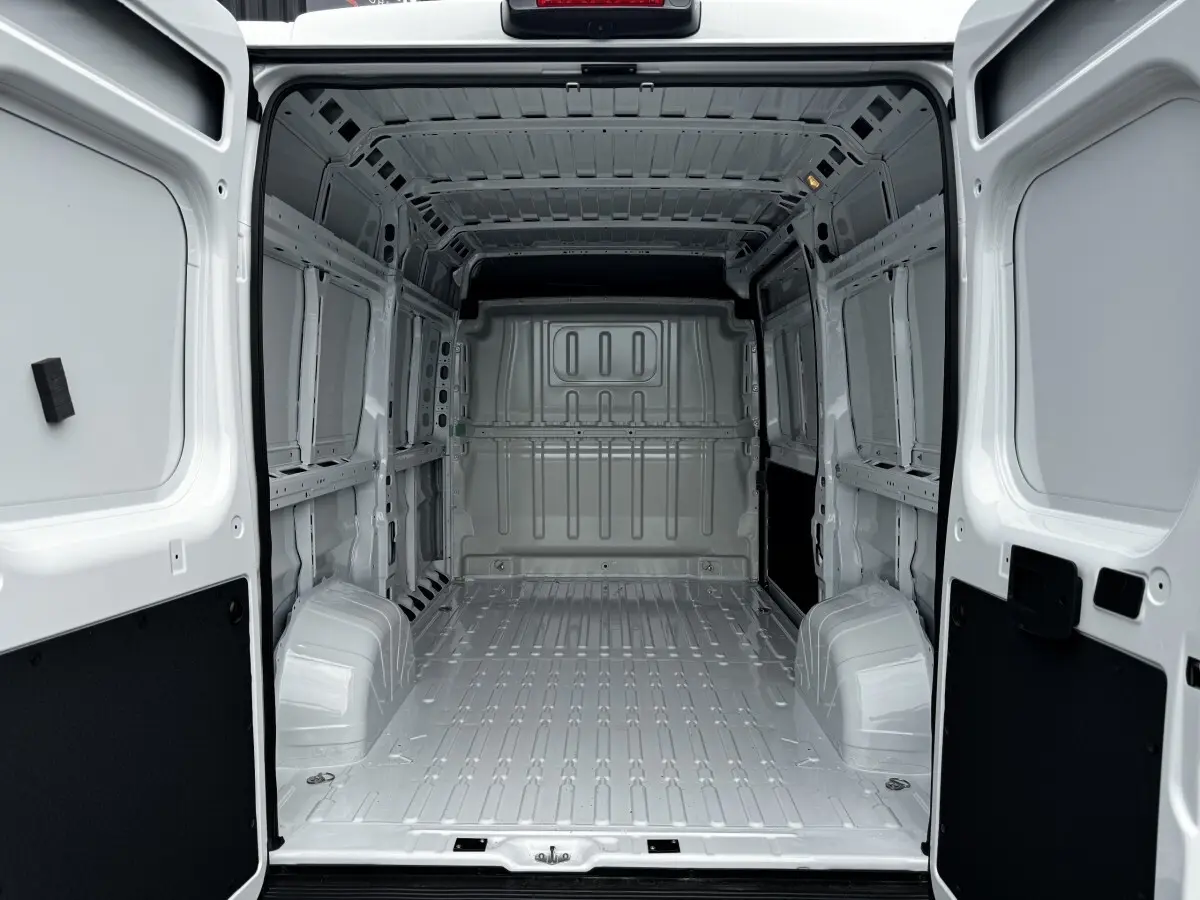 Vue arrière intérieure du Peugeot Boxer Fourgon blanc L2H2, montrant l'espace de chargement vide et la cloison pleine.