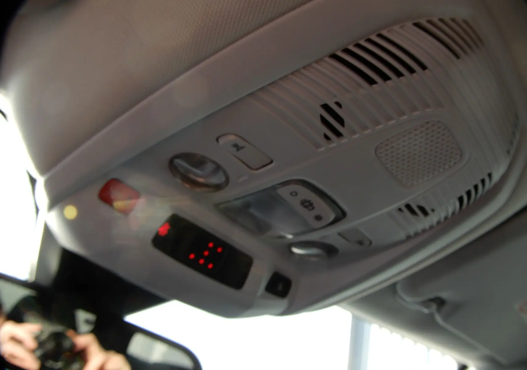 Vue en gros plan du plafonnier intérieur gris clair du Peugeot 5008 blanc nacré, avec commandes et éclairage LED.