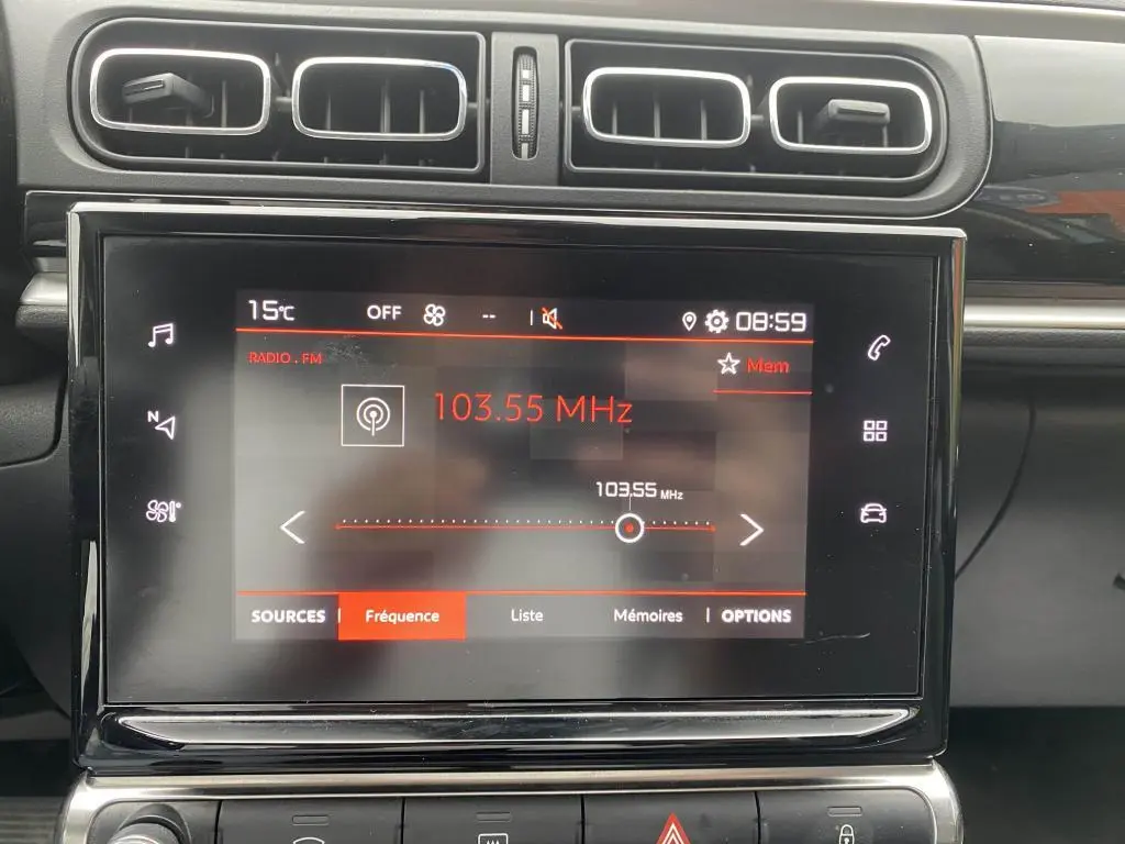 Écran tactile central de la Citroën C3 2023 affichant la radio FM à 103,55 MHz avec aérateurs noirs au-dessus.