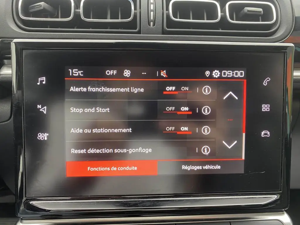 Écran tactile central de la Citroën C3 2023 affichant les réglages d’aides à la conduite, entouré de la console noire.