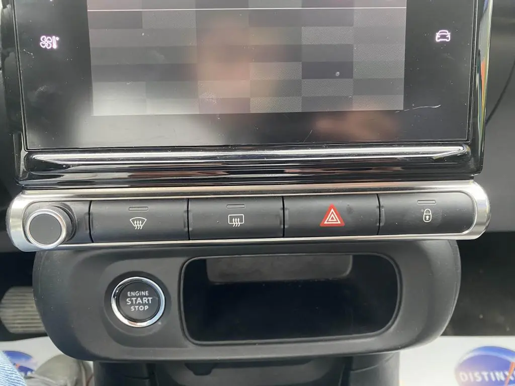 Gros plan sur la console centrale de la Citroën C3 2023, montrant les boutons de commande et le bouton start/stop.