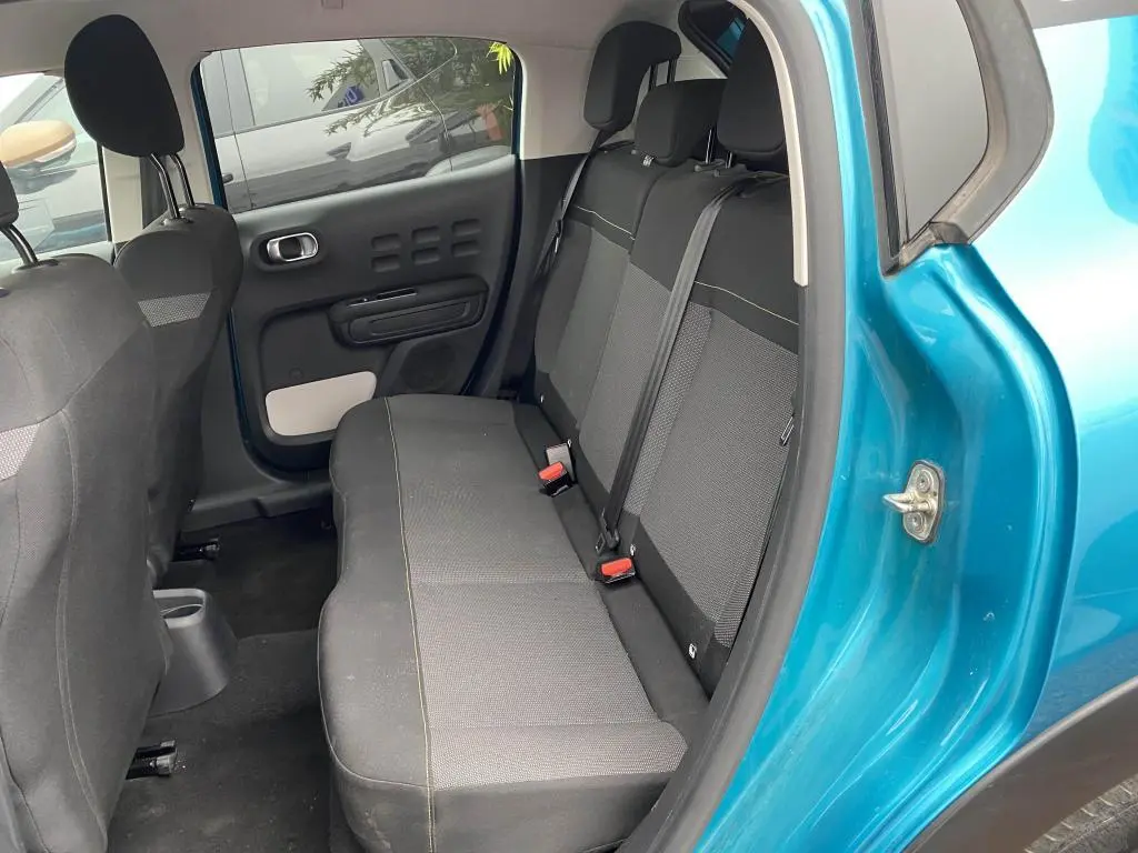 Vue intérieure arrière côté gauche de la Citroën C3 2023 Spring Azul avec banquette noire et détails gris.