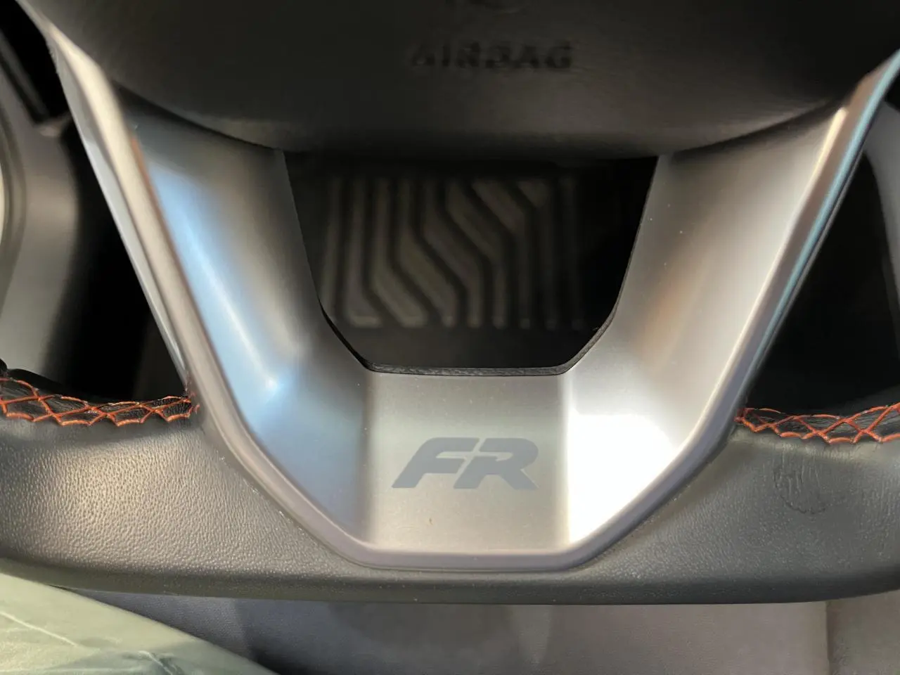 Gros plan sur le volant cuir noir du SEAT Arona FR 2024 avec logo FR et surpiqûres rouges visibles.