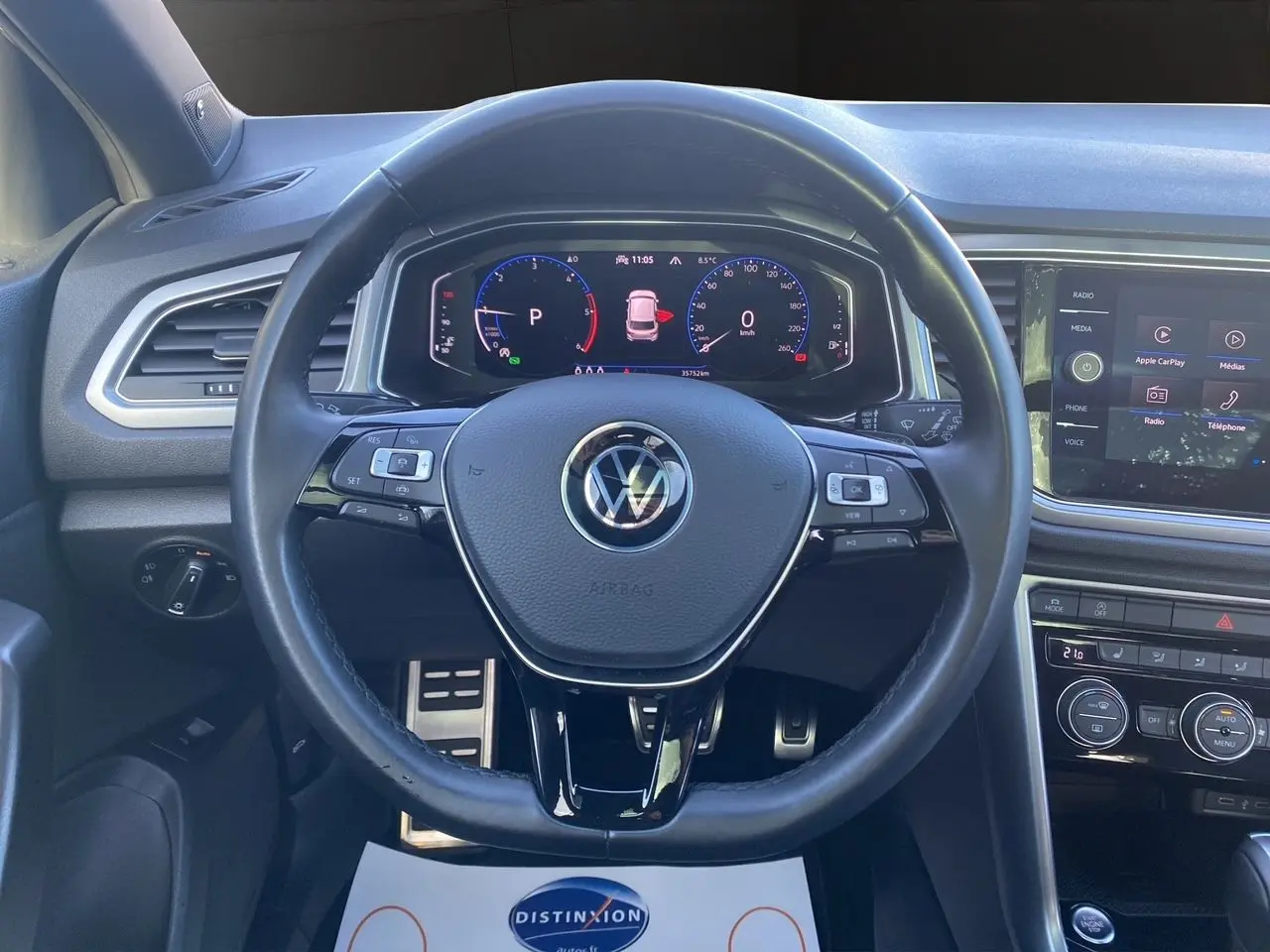 Vue rapprochée du volant noir et du tableau de bord numérique du Volkswagen T-Roc 2.0 TDI 2021, intérieur moderne.