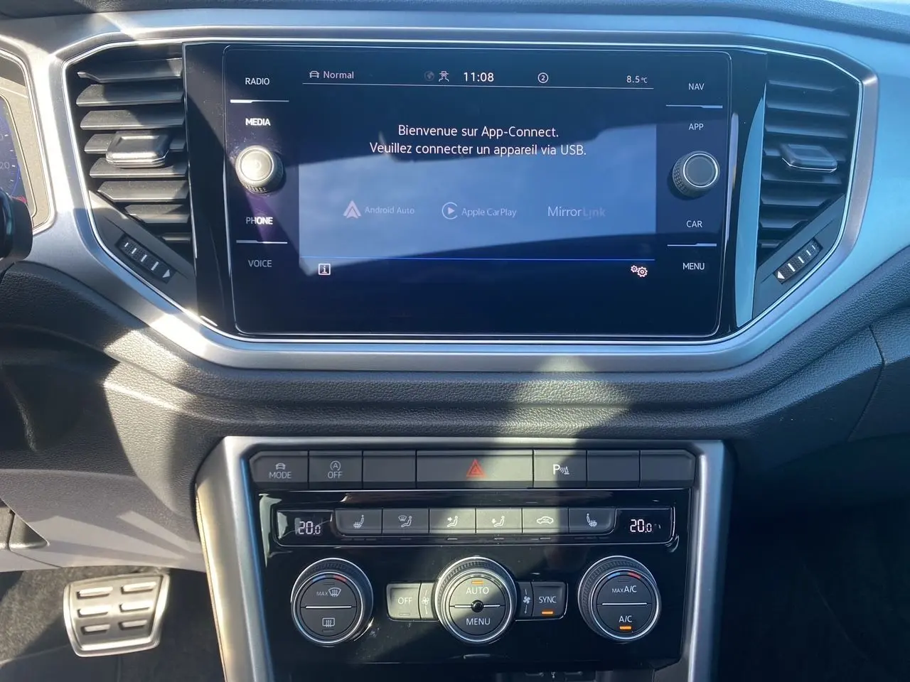 Vue rapprochée du tableau de bord noir du Volkswagen T-Roc 2021 avec écran tactile et commandes de climatisation.