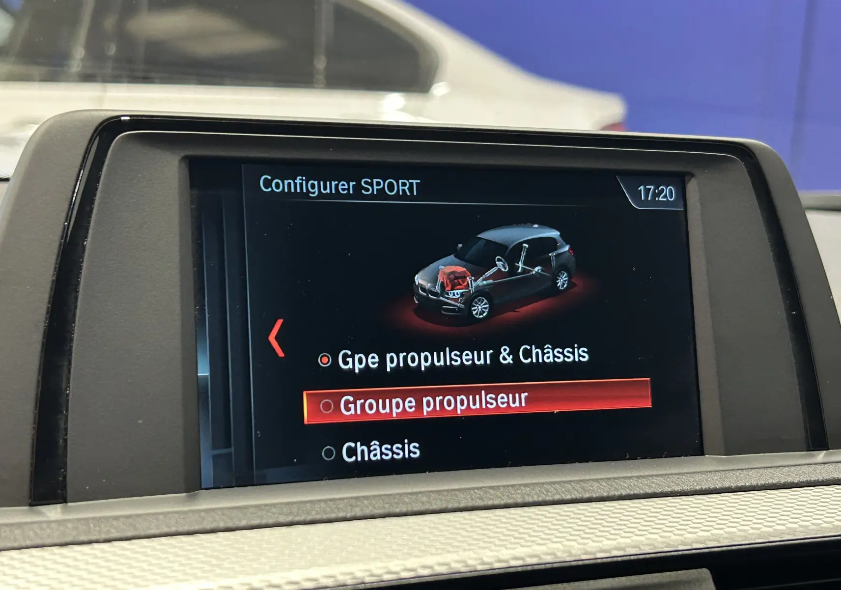 Écran central intérieur d'une BMW Série 1 blanc, affichant le menu de configuration SPORT du groupe propulseur.