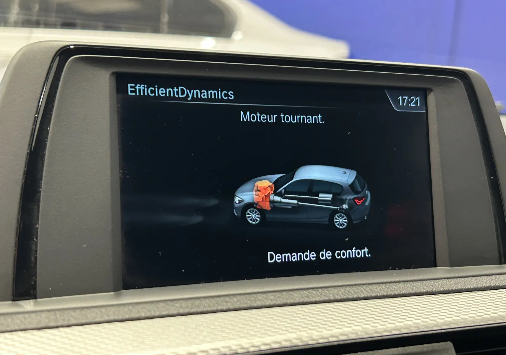 Écran central de BMW Série 1 affichant l'animation moteur tournant avec vue latérale du véhicule gris et toit blanc.