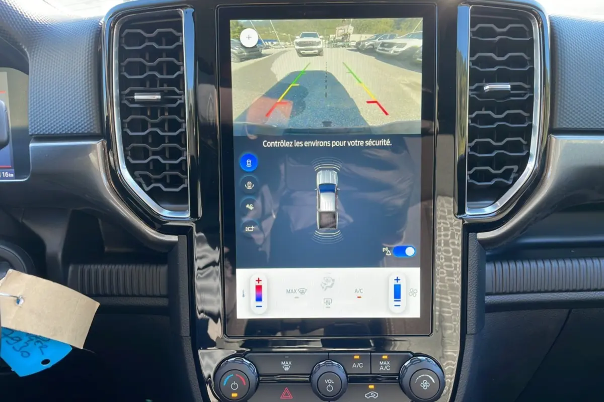 Vue rapprochée de l'écran central tactile du Ford Ranger gris iconic 2025 affichant la caméra de recul et les commandes climatisation.