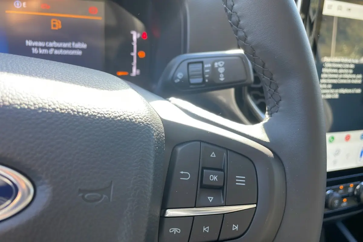 Détail du volant côté gauche du Ford Ranger 2025 gris iconic avec commandes intégrées et tableau de bord numérique.