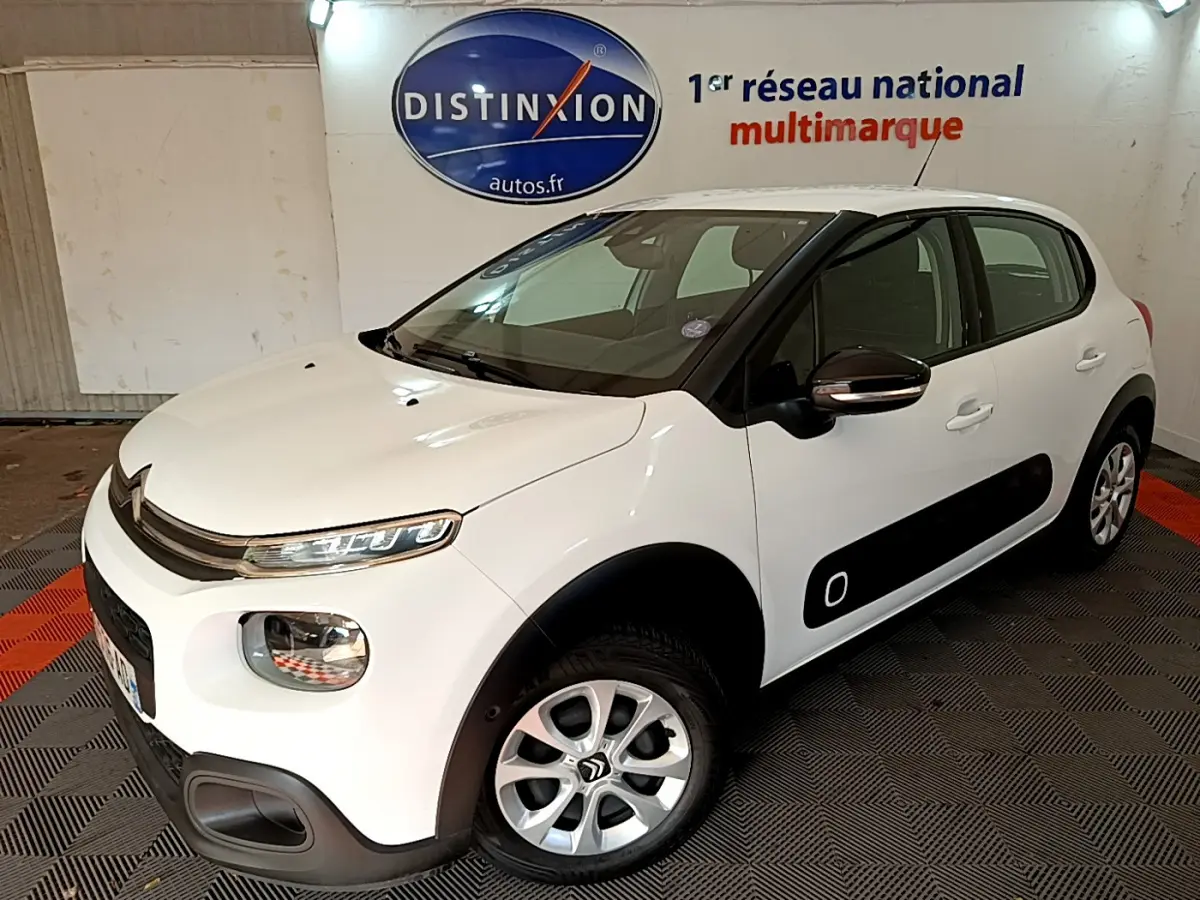 Citroën C3 blanche vue 3/4 avant droit avec protections latérales noires et jantes alliage.