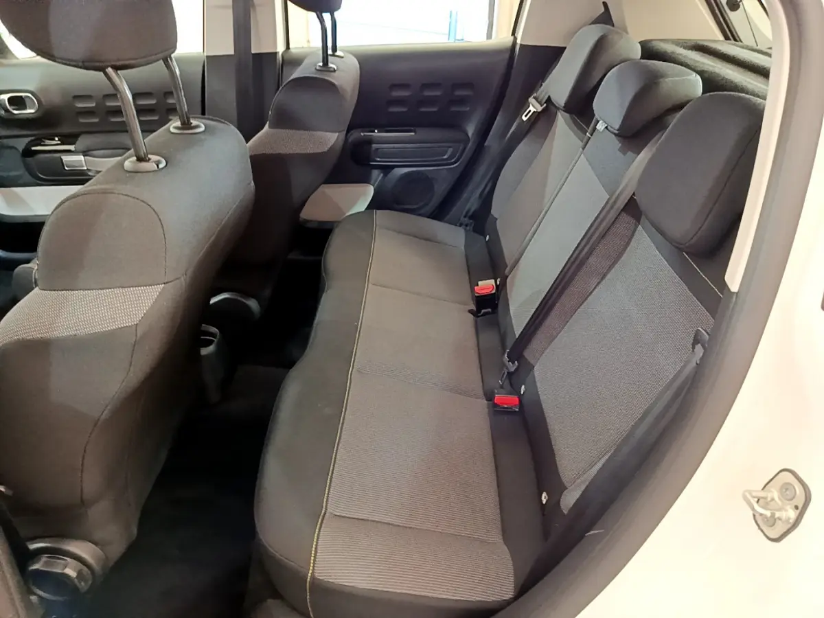Vue intérieure côté droit montrant la banquette arrière grise et noire d'une Citroën C3 blanche de 2019.
