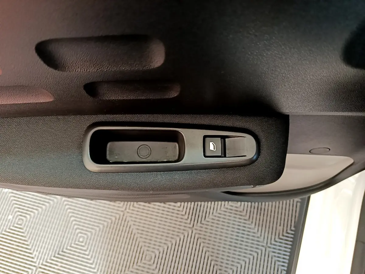 Poignée intérieure noire de la porte côté droit d'une Citroën C3 blanche, avec bouton de verrouillage.