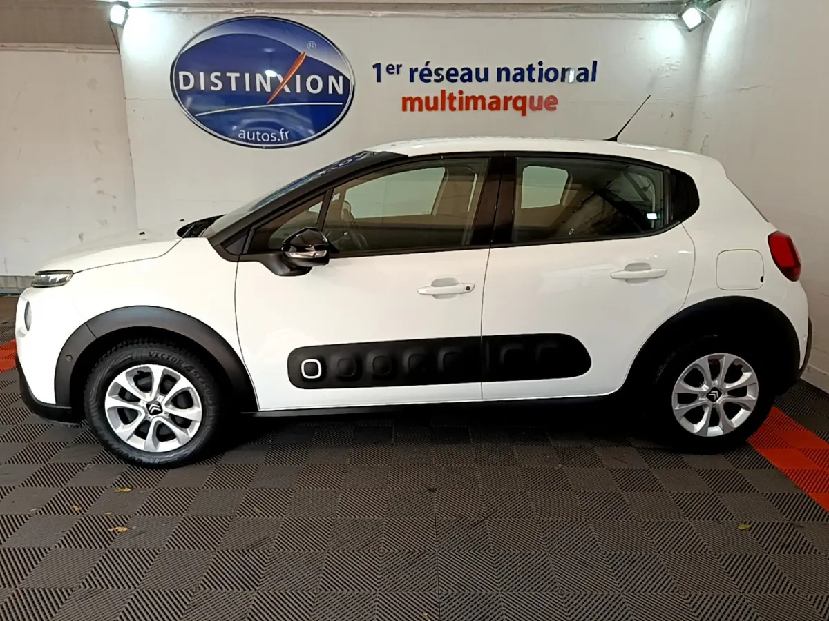 Profil côté gauche d'une Citroën C3 blanche 2019 avec ses protections Airbump noires distinctives sur porte.